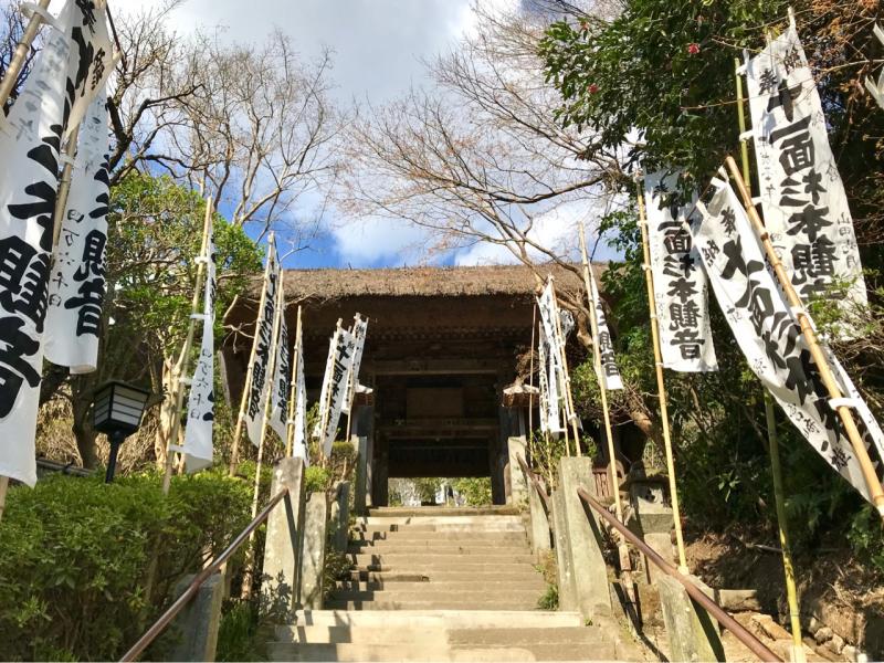 白い奉納旗がはためく階段を登って仁王門へ