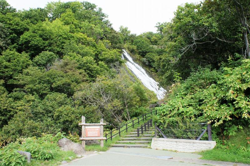 岩肌を這うように流れるオシンコシンの滝と階段の全景