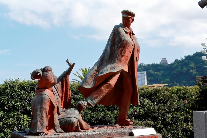 熱海城がそびえる山並みを背景にした貫一お宮の像