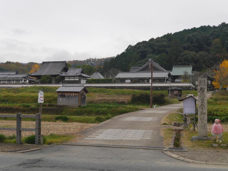 「聖徳太子御誕生所」の石碑の向こうに寺が立つ
