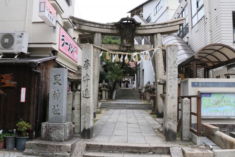 路地の街、尾道らしい、建物の間に石造の鳥居が立つ参道入口